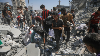 Palestinians search the rubble after an Israeli airstrike demolished a high-rise building in Gaza City, September 5, 2025.