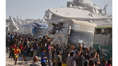 Freed Palestinian prisoners are greeted as their buses pass the rubble in Khan Younis, October 13, 2025.