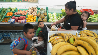 A mother purchases fresh fruits for her children with the last of her SNAP benefits, October 31, 2025.