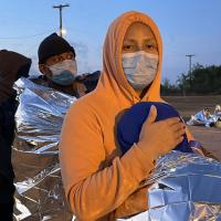 Mother holds her 9 year old as they wait for Border Patrol to take them into custody.