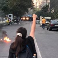 Woman with fist up, no hijab covering her head