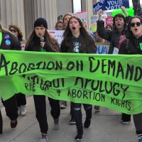 Lansing, Michigan, women march with banner, "Abortion on Demand Without Apology,", October 8, 2022