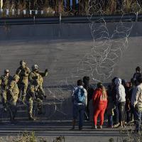 Immigrants stopped by Border Patrol and barbed wire at U.S. Mexico border, December 20, 2022.