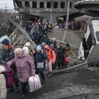 March 5, 2022, Ukraine: People cross path under a bridge destroyed by Russian airstrike.