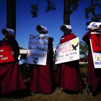 Protesters in Handmaids costumes