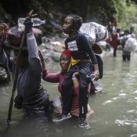 Haitian migrants wade through water as they cross the treacherous Darien Gap from Colombia to Panama.