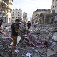 Palestinians collect dead from the rubble after the Israeli bombing in Gaza City, October 11, 2023.