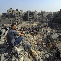A man sits on the rubble as Palestinias search rubble in Jabaliya refugee camp, northern Gaza Strip, after Israeli airstrike, November 1, 2023.