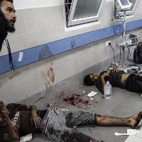 Wounded Palestinians lie on the floor in al-Shifa hospital in Gaza City