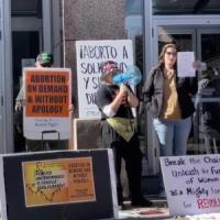 Protesters with signs: Break the Chains, Unleash the Fury of Women as a Mighty Force for Revolution