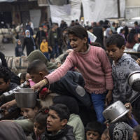 Children getting food and water in Gaza at a packed relief station