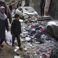 Woman and child walk through the destruction in Rafah, Gaza from Israeli airstrike, February 9, 2024,