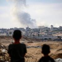 Gaza: two young children looking at bomb blast in the hills.
