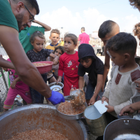 Displaced Palestinian children line up for food in a camp in Deir al-Balah, Gaza, October 18, 2024.