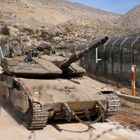 Israeli tank maneuvers next to the security fence that separates the Israeli-annexed Golan Heights from Syria, December 11, 2024.