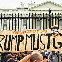 Refuse Fascism banner "Trump Must Go Now" in front of the White House gates.