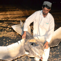 A Pakistani villager holds the wreckage of a U.S. drone that crashed along the border with Afghanistan, August 25, 2011.