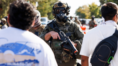 Federal officers stand guard on Chicago’s Southwest Side, after protesters learned that U.S. Border Patrol shot a woman that morning.