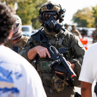 Federal officers stand guard on Chicago’s Southwest Side, after protesters learned that U.S. Border Patrol shot a woman that morning.
